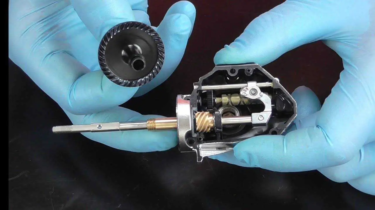 A technician carefully adjusting the gears of a fishing reel.